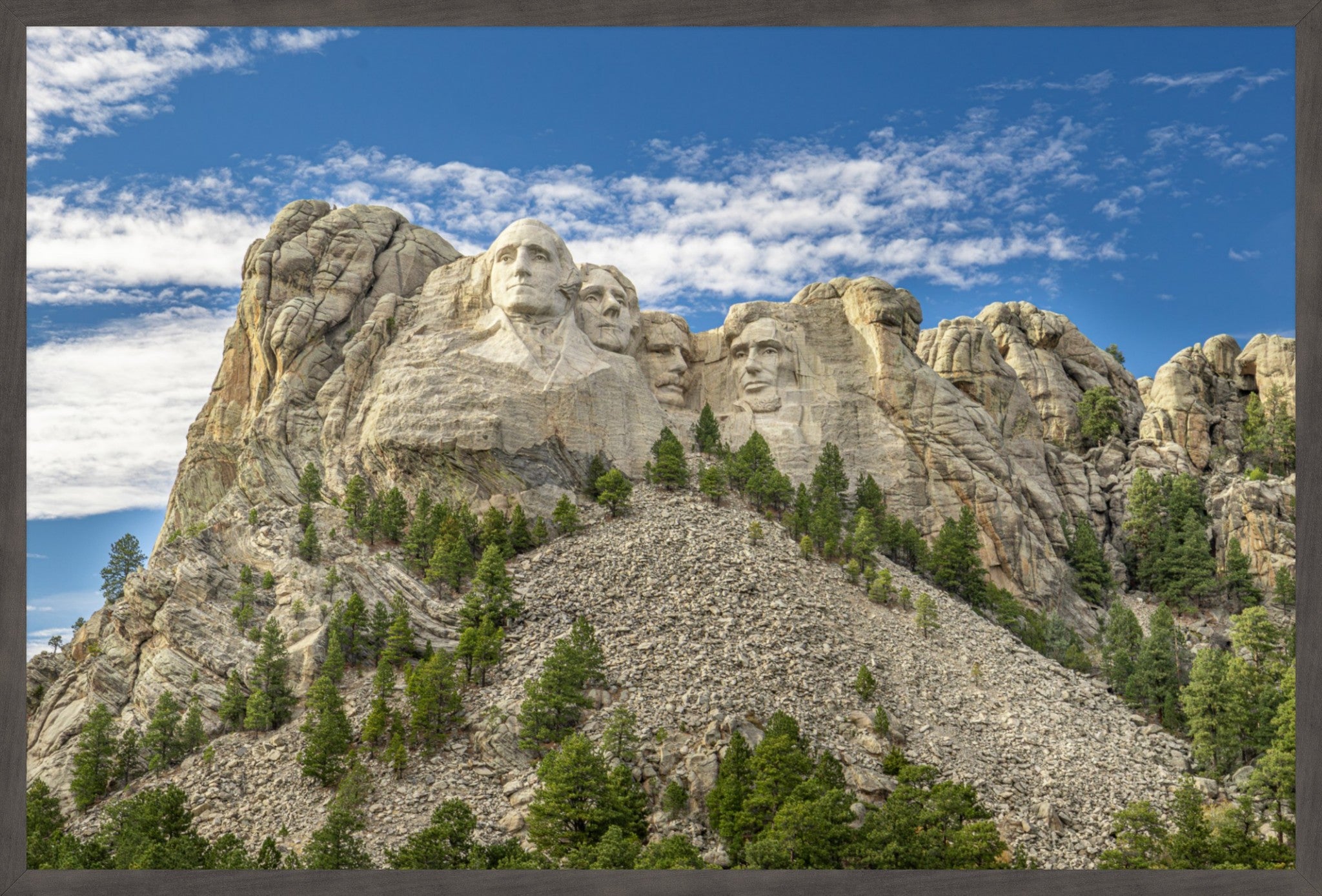 A framed landscape photograph of Mount Rushmore National Monument, showing the carved faces of four U.S.
