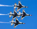 Four fighter jets performing a formation flight against a clear blue sky.